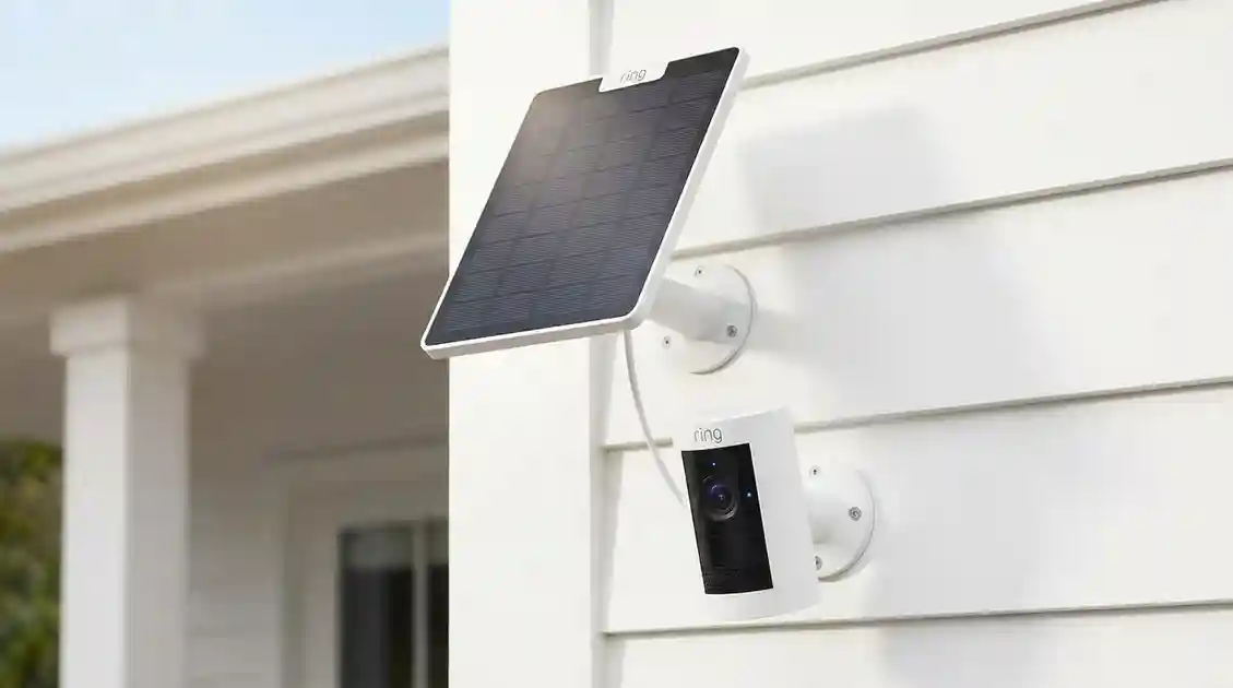 Ring Stick Up Cam mounted outdoors next to its connected solar panel